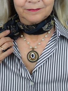 repurposed black and white cameo necklace worn with scarf and striped shirt