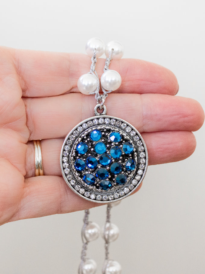 azure blue vintage pearl necklace draped over hand