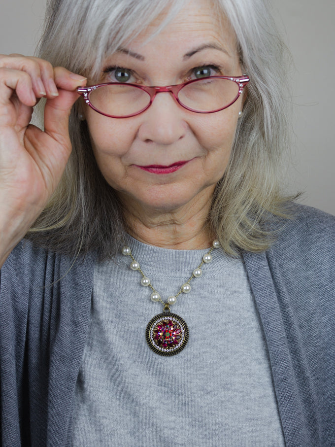 wearing fuchsia rhinestone pearl necklace with gray sweater