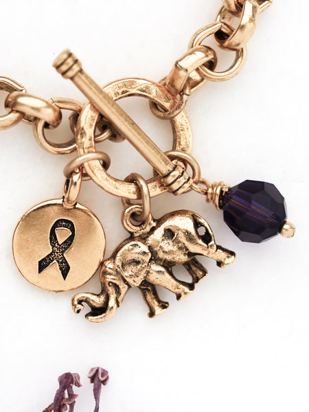 Alzheimer's bracelet closeup on elephant, awareness charm and purple crystal