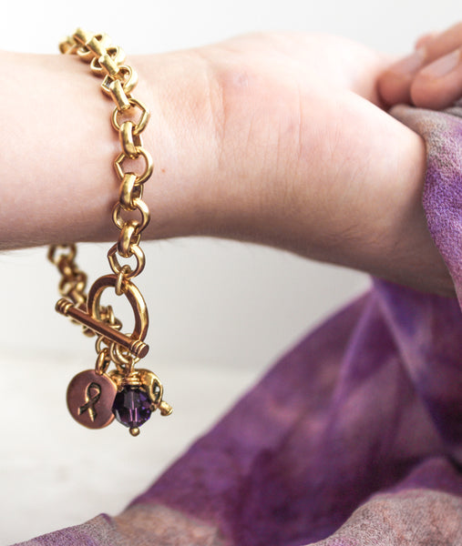 Gold alzheimer's bracelet with elephant, awareness ribbon, and purple Swarovski crystal