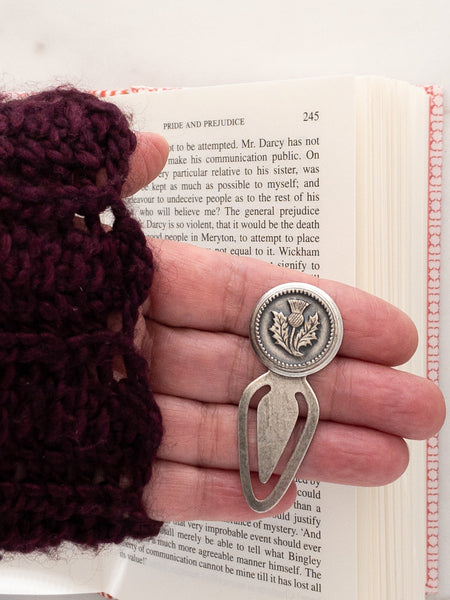 Hand holding antique thistle button bookmark